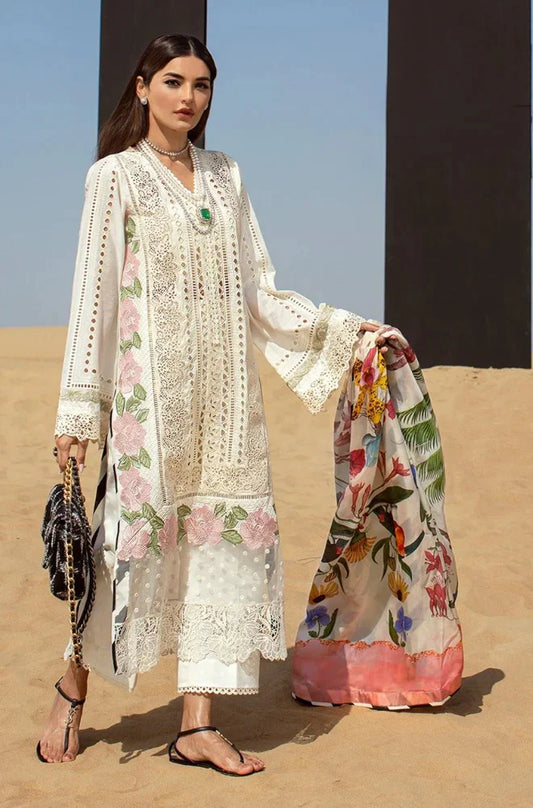Woman in a white embroidered outfit with a colorful scarf against a desert background
