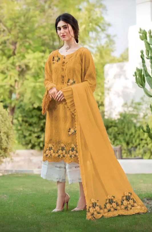 Woman wearing a mustard yellow traditional outfit with embroidery in an outdoor setting.