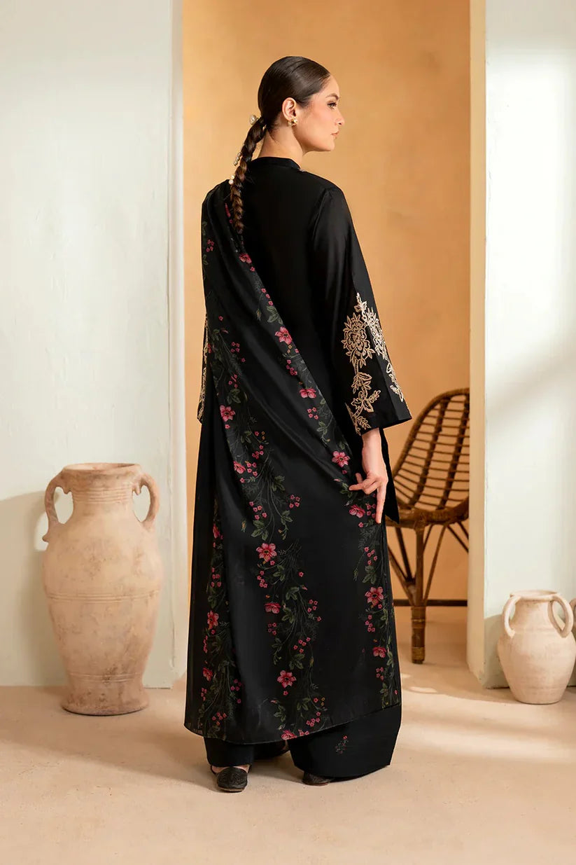 Woman wearing a black outfit with floral patterns in a minimalistic setting