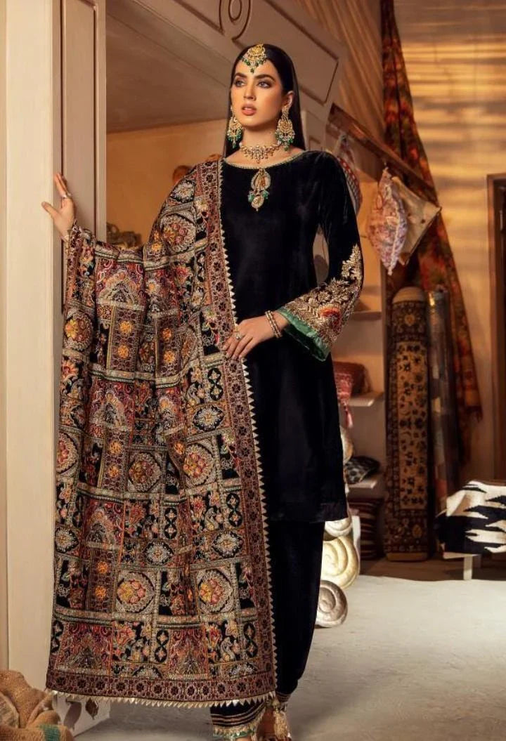 Woman in traditional black outfit with embroidered shawl in a decorated room