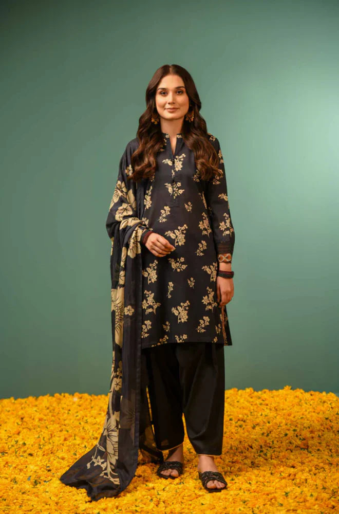 Woman in a black floral outfit standing on yellow flowers with a green background