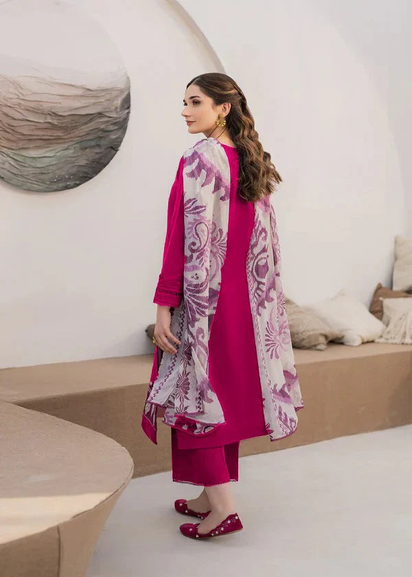 Woman wearing a pink traditional outfit with a floral dupatta in a modern indoor setting.