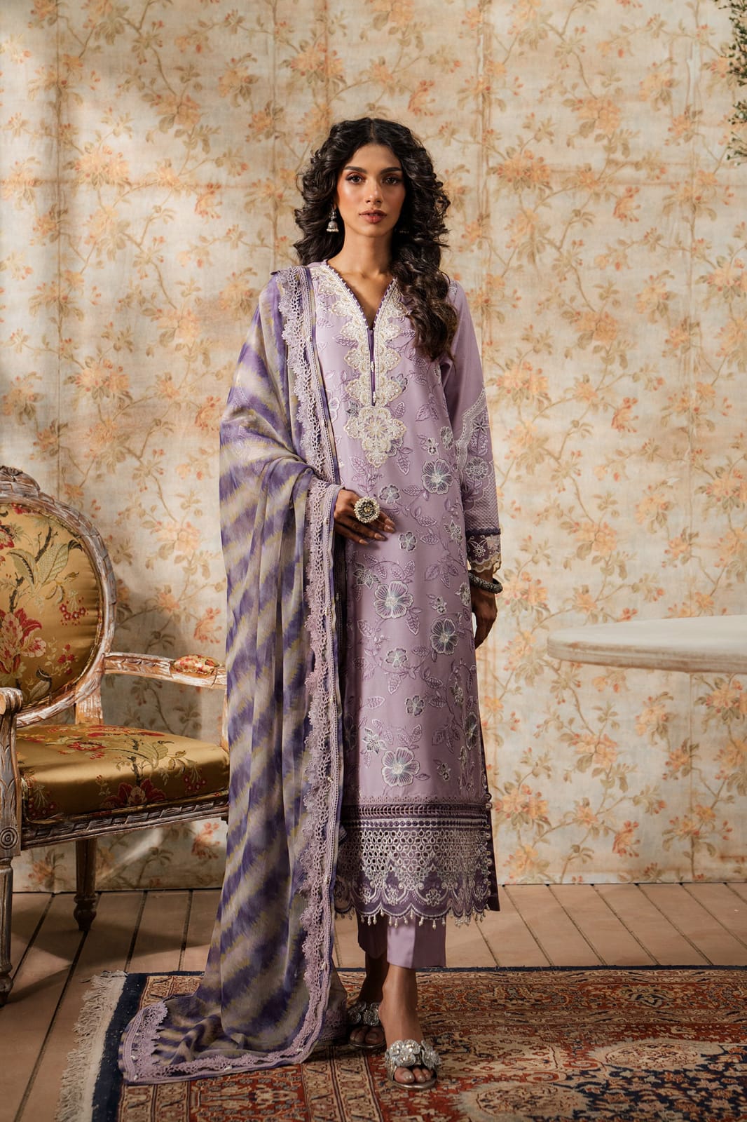 Woman in a lavender traditional outfit with a floral background