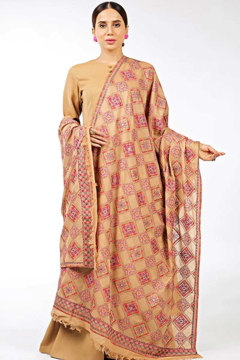 Woman wearing a beige saree with red patterns on a white background