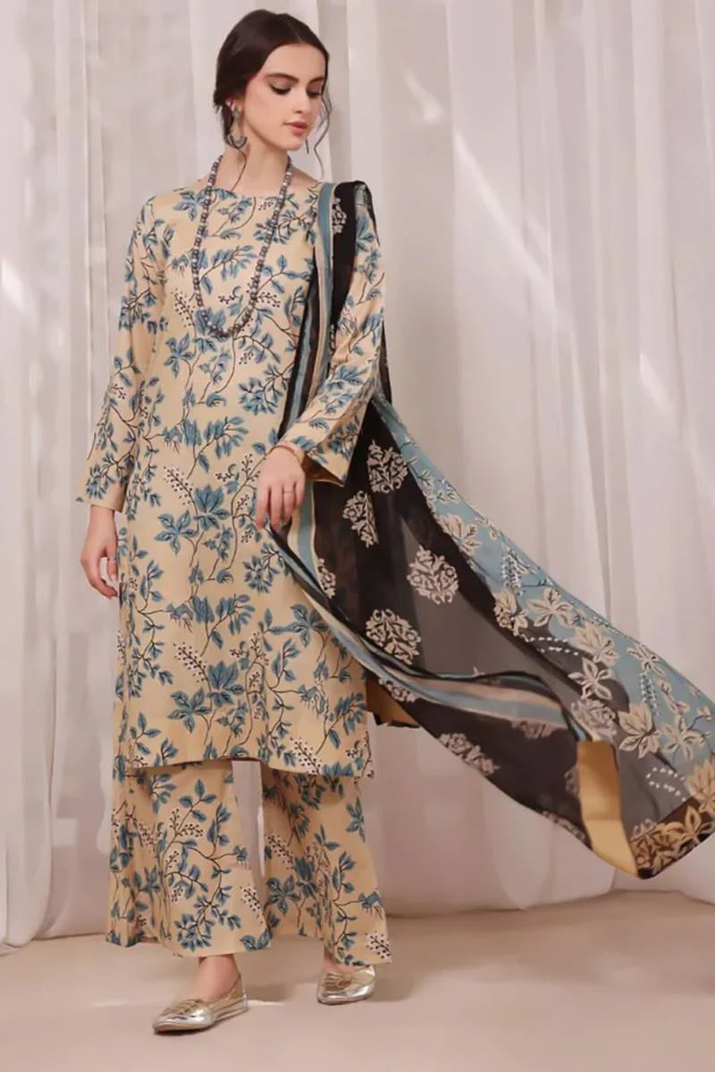 Woman wearing a floral outfit with a black dupatta against a white curtain background